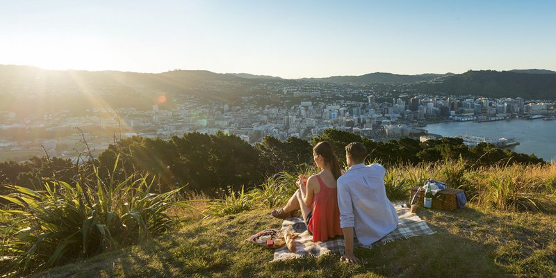 Couple-picnicing-at-sunset-on-Mt-Victoria__FocusFillWzEyMDAsNjAwLCJ5IiwxMDBd.jpg